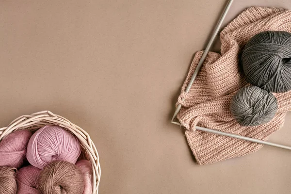 Las bolitas del hilo de lana merino, tejiendo a las agujas de punto sobre la superficie beige. Vista superior —  Fotos de Stock