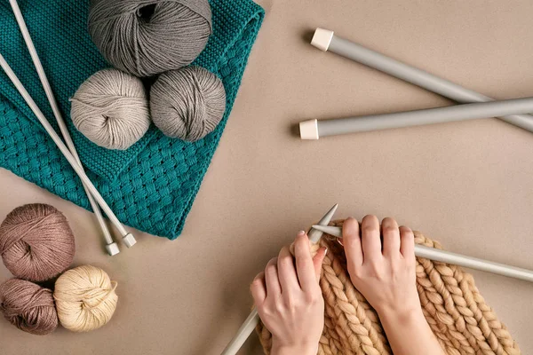 Primo piano di maglione di lana lavorante a maglia di mani femminili o colore beige plaid. Vista dall'alto — Foto Stock