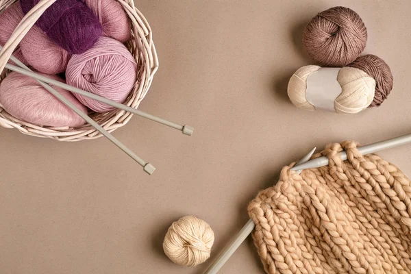 Palle di filato di lana merino, lavorare a maglia su ferri da maglia su una superficie beige. Vista dall'alto — Foto Stock