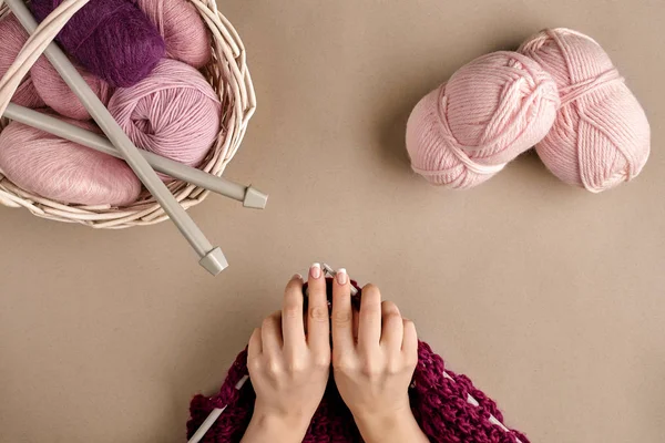 Primer plano de las manos femeninas tejiendo suéter de lana o color lila a cuadros. Vista superior —  Fotos de Stock