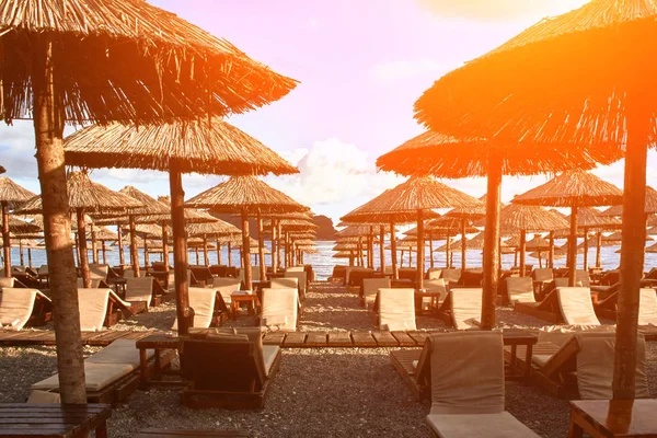 Sun loungers and umbrellas are on the beach in Budva, Montenegro. Sun flare — Stock Photo, Image