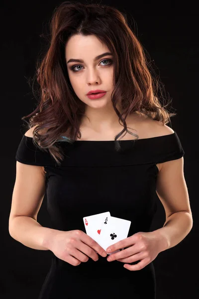Mladá žena držící hrací karty na černém pozadí — Stock fotografie