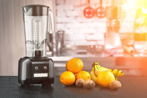 Metal food blender close-up with fresh exotic tropic fruits next to it on kitchen background with empty space. Sun flare — Stock Photo, Image