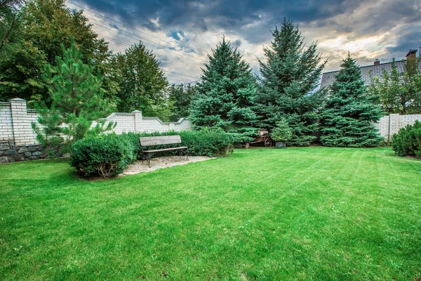 Holzbank in einem schönen Parkgarten. — Stockfoto