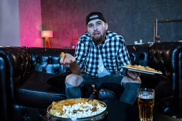 Young fanatic man watching football game on television nervous a