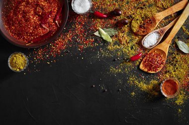 Koyu siyah arka plan üzerine çeşitli baharatlar. Baharat gıda için. Köri, kırmızı biber, biber, kakule, zerdeçal. Üstten görünüm.