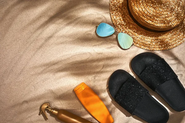 Fond d'été avec chapeau de paille, lunettes de soleil, bouteille de crème solaire et tongs — Photo