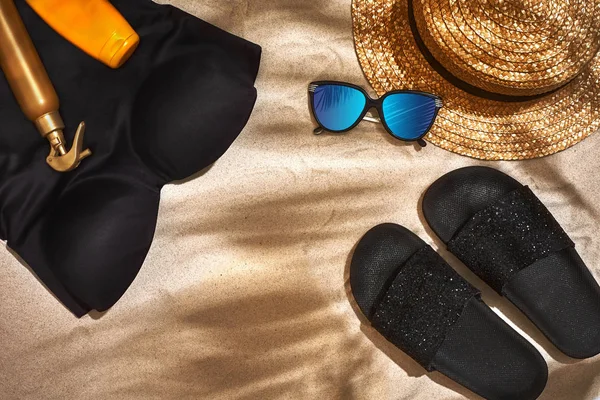 Fondo estivo con cappello di paglia, occhiali da sole, bottiglia di crema solare e infradito — Foto Stock