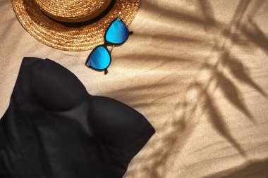 Bayan plaj aksesuarları veya kum zemin üzerine yaz kıyafeti. Kopya alanı ile üstten görünüm