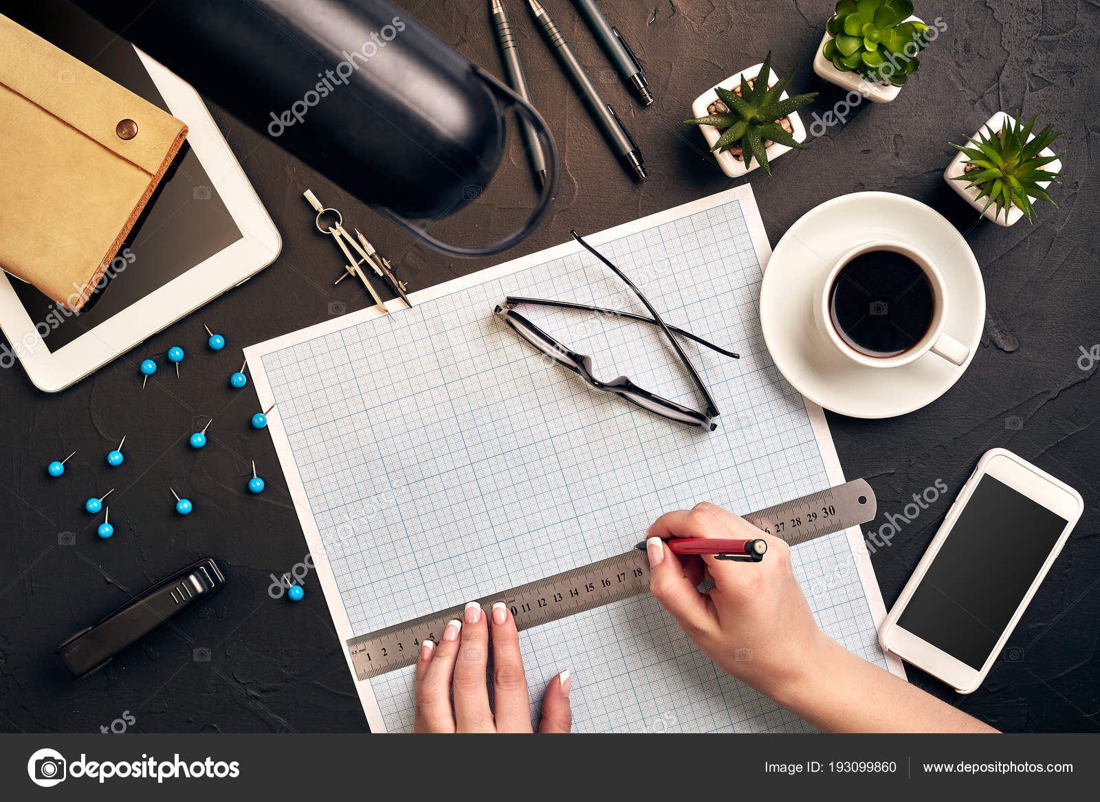 Office desk background hand with pen writing construction project ideas  concept. With tablet, drawing equipment and a cup of coffee. View from  above Stock Photo by ©@ 193099860