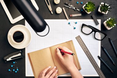 Konsept Mimarlar. Mimarlar işyeri, mimari proje, planları, cetvel. Mühendis ve bir kalem tutan bir defterde yazıyor. Ofiste bir plan ile masaya ekipman Mimarlar.