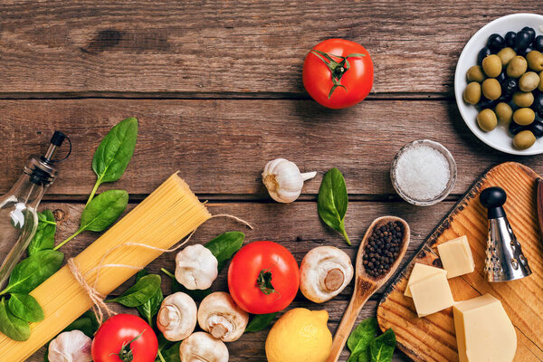 Italian food background with pasta, spices and vegetables. Top view, copy space.