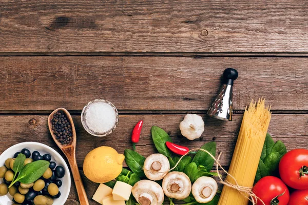 Italian food ingredients for the preparation pasta on wooden background