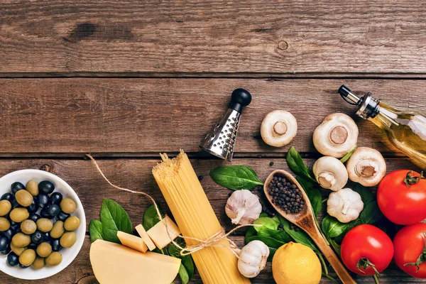 Makarna malzemeler - domates, zeytin yağı, sarımsak, İtalyan otlar, taze fesleğen, tuz ve spagetti kopya alanı ahşap bir zemin üzerine, yatay, yukarıdan görünüm