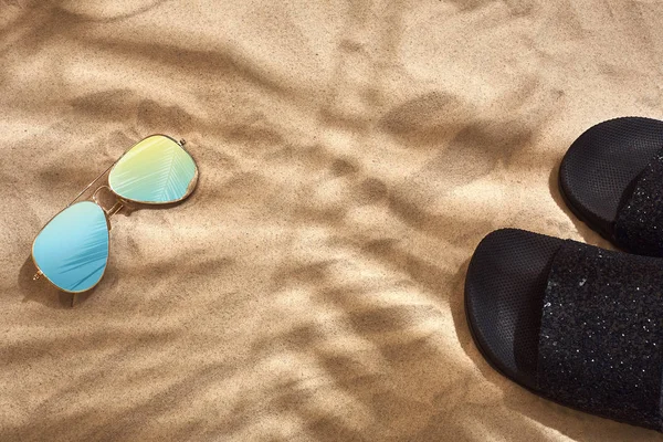 Σανδάλι και γυαλιά ηλίου σε αμμώδη φόντο, το top view — Φωτογραφία Αρχείου