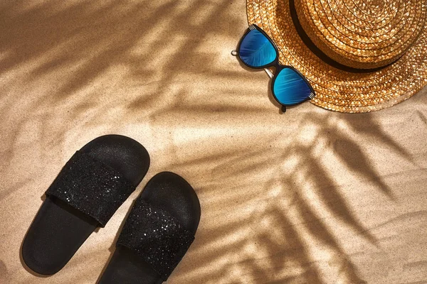 Sandal, straw hat and sunglasses on a sandy background, top view — Stock Photo, Image