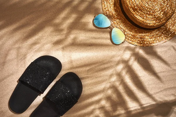 Σανδάλι, ψάθινο καπέλο και γυαλιά ηλίου σε αμμώδη φόντο, το top view — Φωτογραφία Αρχείου