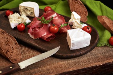 Peynir, salam, ekmek, sebze ve baharat kopya alanı siyah zemin üzerine ahşap tahta üzerinde