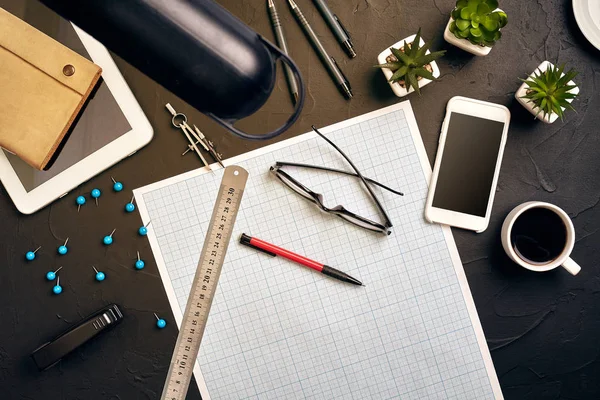 Top view of the builders workplace, ruler, paper for drawings, compasses, glasses, tablet