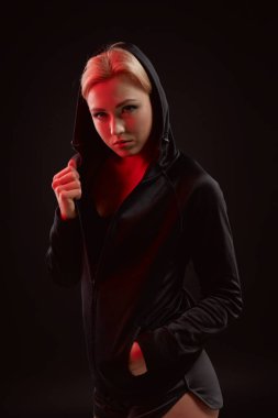 Stüdyoda siyah kapüşon, spor iç çamaşırı ve küçük siyah şort ince seksi şekilde baştan çıkarıcı sportif kızla güzel poz