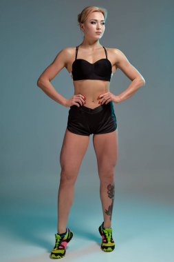 Fitness kadında siyah kolsuz bluz ve şort, stüdyo vurdu.