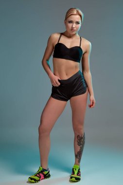 Fitness kadında siyah kolsuz bluz ve şort, stüdyo vurdu.