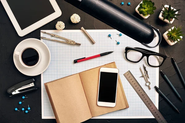 Engineers desk in office with various gadgets and documents