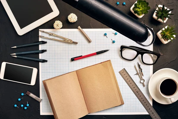 Engineers desk in office with various gadgets and documents