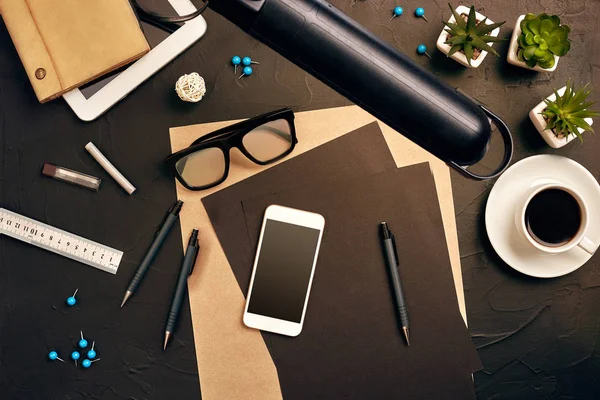 Engineers desk in office with various gadgets and documents