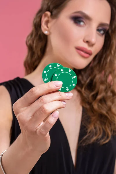 ピンクの背景のポーカー用のチップを持つ美しい若い女性の肖像画 — ストック写真