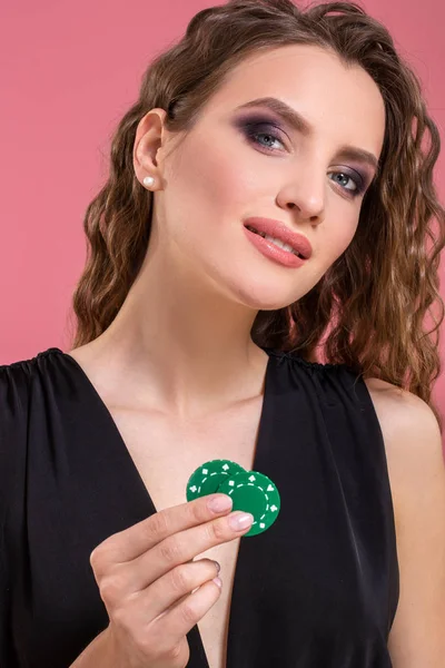Retrato de uma bela jovem com fichas de poker em fundo rosa — Fotografia de Stock