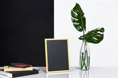 Poster çerçevesi, yukarı sahte ile şık iç tablo arka plan üzerinde siyah ve beyaz duvar ile cam şişe içinde bırakır.