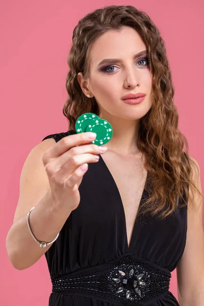 Retrato de una hermosa joven con fichas de póquer sobre fondo rosa — Foto de Stock