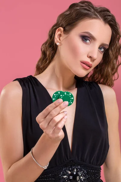 Portrét krásné mladé ženy s poker žetony na růžovém pozadí — Stock fotografie