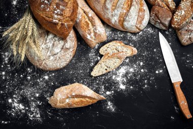 Ev yapımı çavdar ekmeği un ve çeşitli tahıl ve tohum spikelets buğday veya çavdar ve yulaf siyah bir zemin üzerine serpilir.