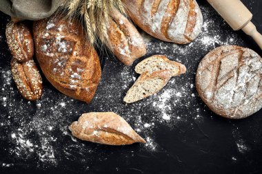 Ev yapımı çavdar ekmeği un ve çeşitli tahıl ve tohum spikelets buğday veya çavdar ve yulaf siyah bir zemin üzerine serpilir.