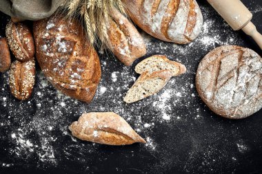 Ev yapımı çavdar ekmeği un ve çeşitli tahıl ve tohum spikelets buğday veya çavdar ve yulaf siyah bir zemin üzerine serpilir.