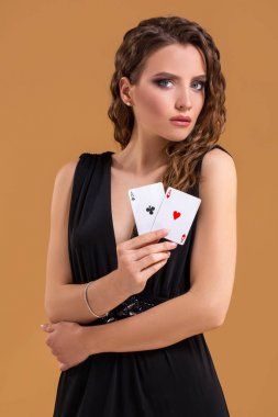 İki as poker oyunu, kumar ve casino için bir işaret olarak tutan güzel kahverengi saçlı kadın