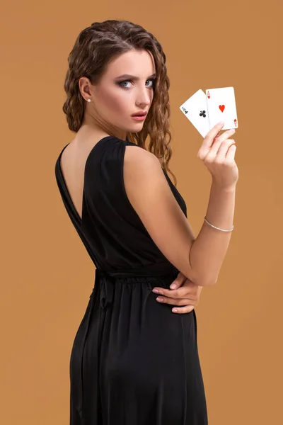 Belle femme aux cheveux bruns tenant deux as comme signe pour le jeu de poker, le jeu et le casino — Photo