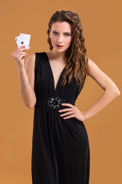 Krásná hnědovlasá žena držící dvě esa jako znamení pro hru poker, hazardní hry a kasino — Stock fotografie