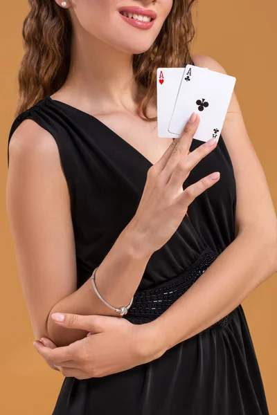 Vackra brunhårig kvinna som håller två ess som ett tecken för pokerspel, spel och kasino — Stockfoto