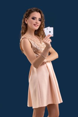 Poker kartları kazanan kombinasyonu koyu mavi arka plan üzerinde tutan genç güzel kadın. İki as