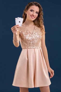 Poker kartları kazanan kombinasyonu koyu mavi arka plan üzerinde tutan genç güzel kadın. İki as