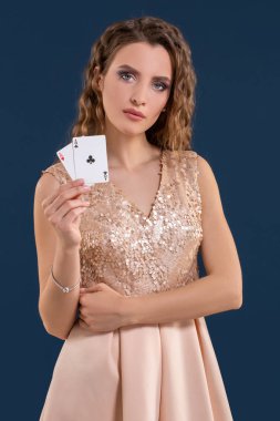 Poker kartları kazanan kombinasyonu koyu mavi arka plan üzerinde tutan genç güzel kadın. İki as