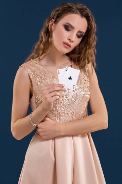 Poker kartları kazanan kombinasyonu koyu mavi arka plan üzerinde tutan genç güzel kadın. İki as