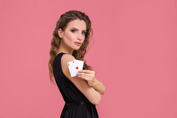 Mladá žena držící v ruce dvě esa proti na růžovém pozadí — Stock fotografie