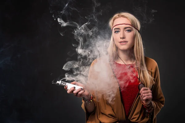 Szexi fiatal csípő dohányzás vaping lány portréja. A nő öltözve egy boho stílusát. Vapor koncepció. Vaping e-cigaretta. — Stock Fotó