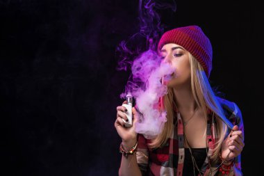 Vaping kız. Genç hipster kadın vape e-cig studio siyah arka plan üzerinde. Hip-hop tarzı. Yakın çekim.