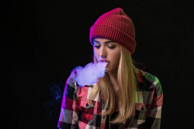 Vaping kız. Genç hipster kadın vape e-cig studio siyah arka plan üzerinde. Hip-hop tarzı. Yakın çekim.