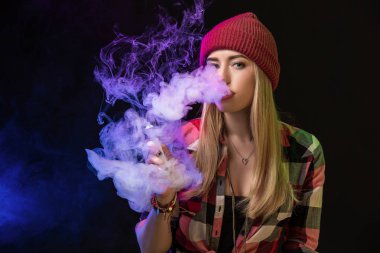 Vaping kız. Genç hipster kadın vape e-cig studio siyah arka plan üzerinde. Hip-hop tarzı. Yakın çekim.